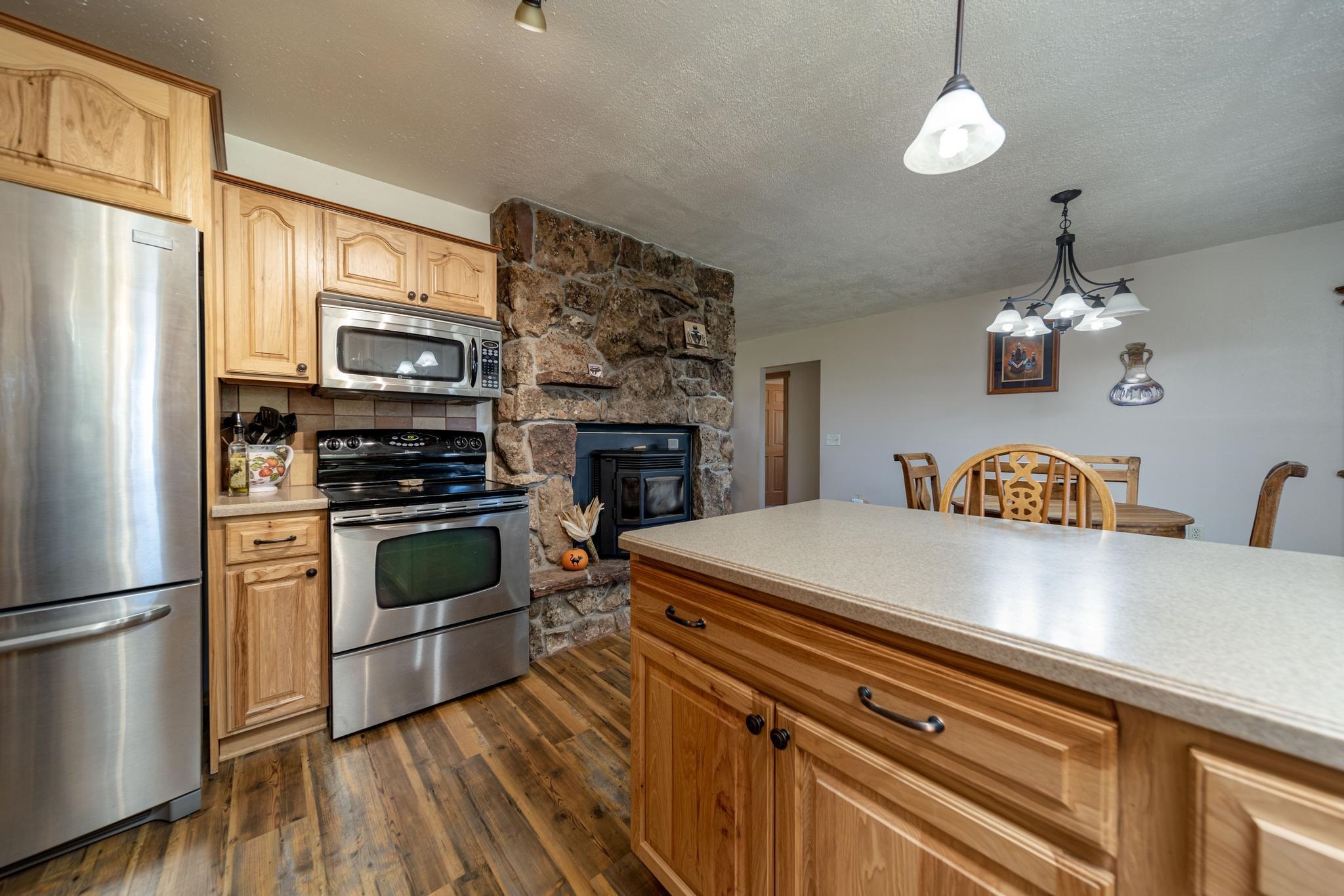 2034 J Road Fruita, CO 81521 - Photo 10 of 38 a kitchen with stainless steel appliances a stove refrigerator and a fireplace