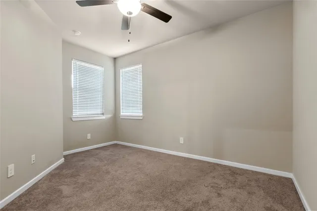 an empty room with windows and cabinet