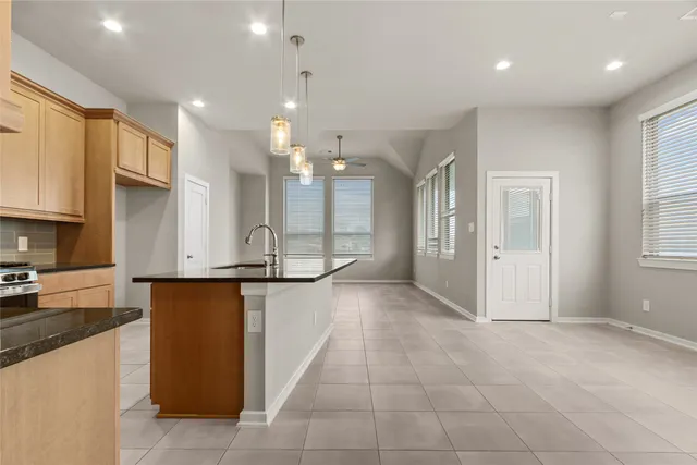 a large kitchen with granite countertop a large counter top stainless steel appliances and cabinets