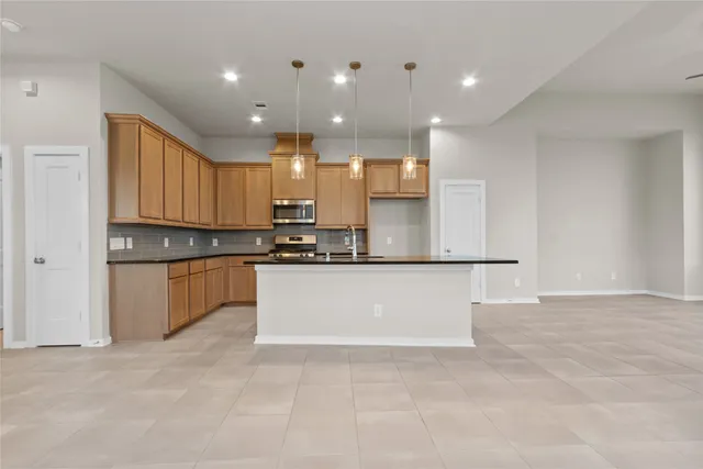 a large kitchen with kitchen island a sink stainless steel appliances and cabinets
