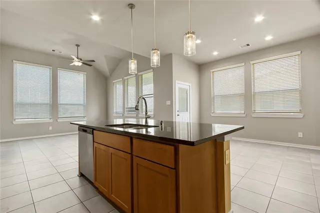 a bathroom with a sink a large mirror and a bathtub next to a window