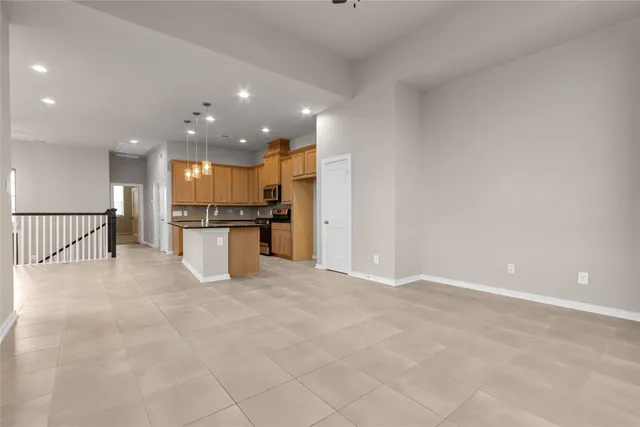a view of kitchen with refrigerator and white cabinets