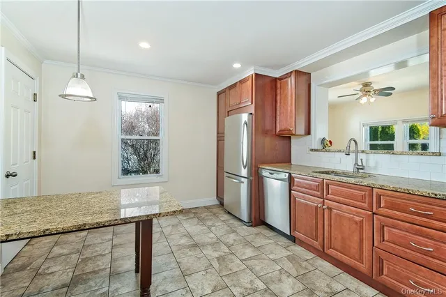 a kitchen with stainless steel appliances granite countertop a refrigerator and a sink