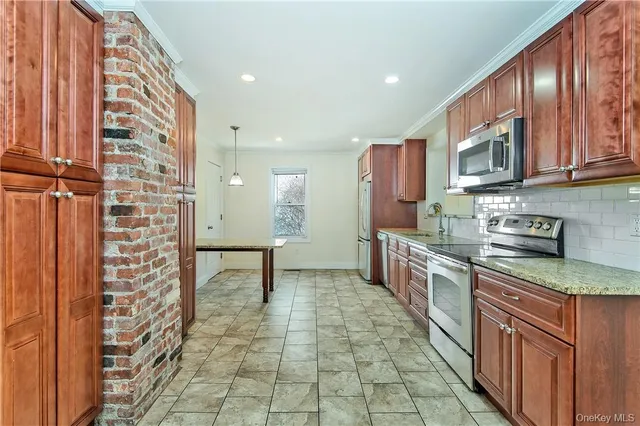 a large kitchen with stainless steel appliances granite countertop a stove and a cabinets