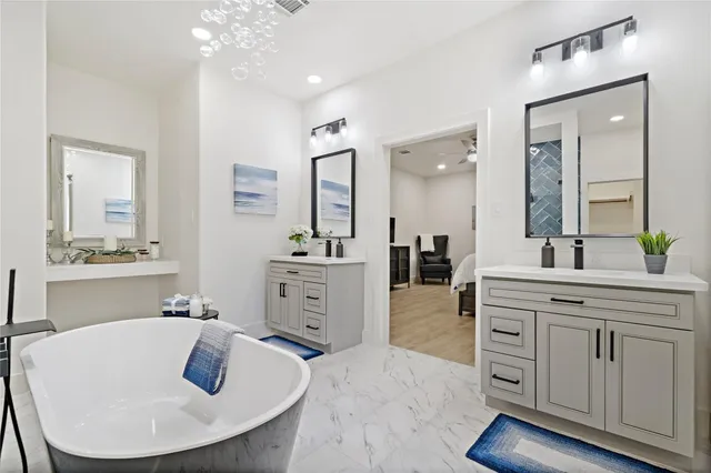 a spacious bathroom with a granite countertop sink a mirror a vanity and bathtub