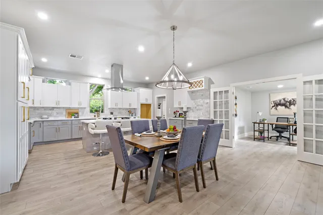 a view of a dining room with furniture a chandelier and wooden floor