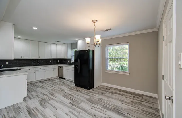 a kitchen with a refrigerator and a stove top oven