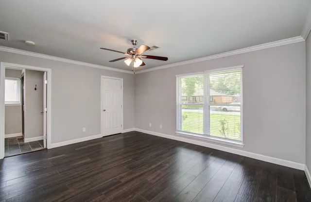an empty room with wooden floor and window