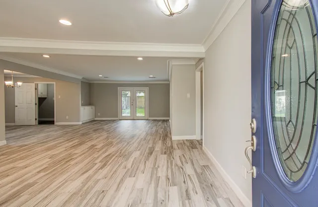 a view of a hallway with wooden floor and a chandelier