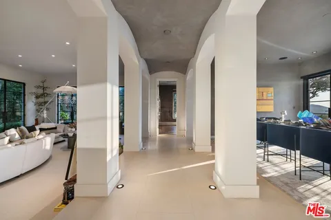 a living room with furniture flowerpot and a chandelier