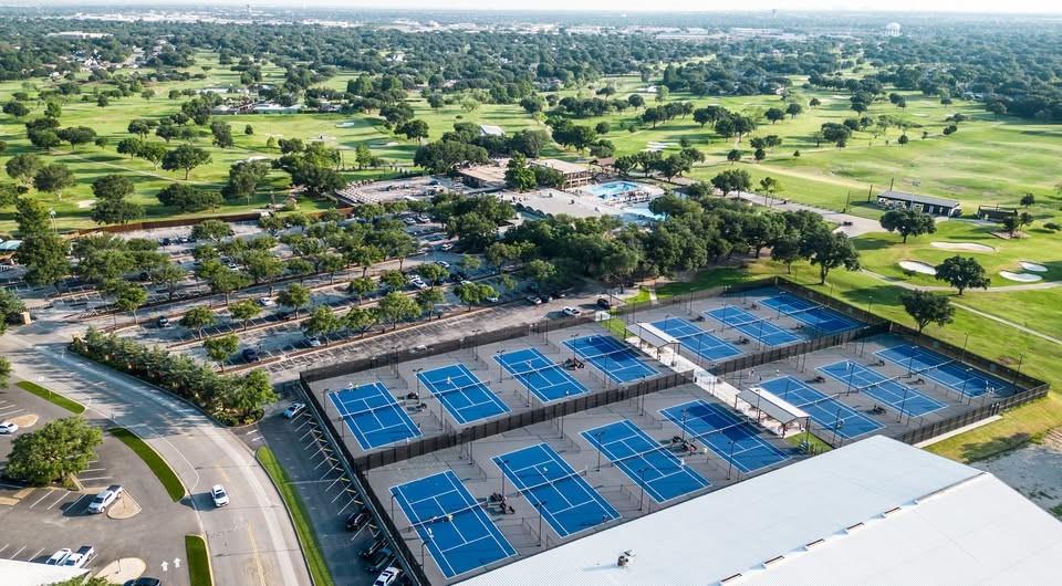 1382 East Crosby Road Carrollton, TX 75006 - Photo 22 of 28 Premier sports facility featuring multiple professional-grade hard courts with blue playing surfaces, expansive covered pavilion structure, and manicured grounds surrounded by mature landscaping