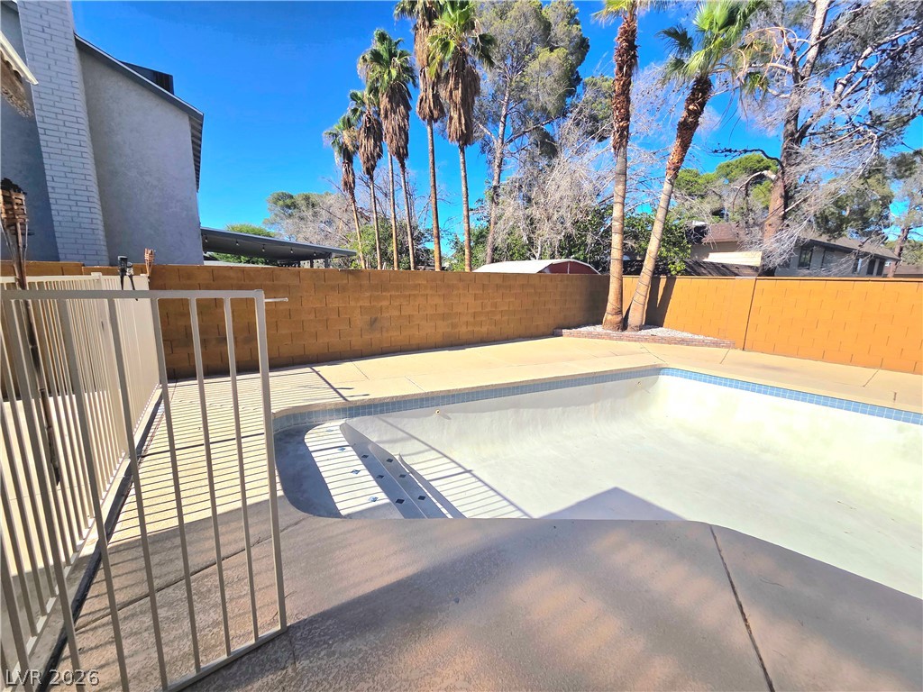 3648 Bronco Road Las Vegas, NV 89103 - Photo 16 of 24 An inviting backyard features a pristine, empty pool, ready for summer enjoyment.