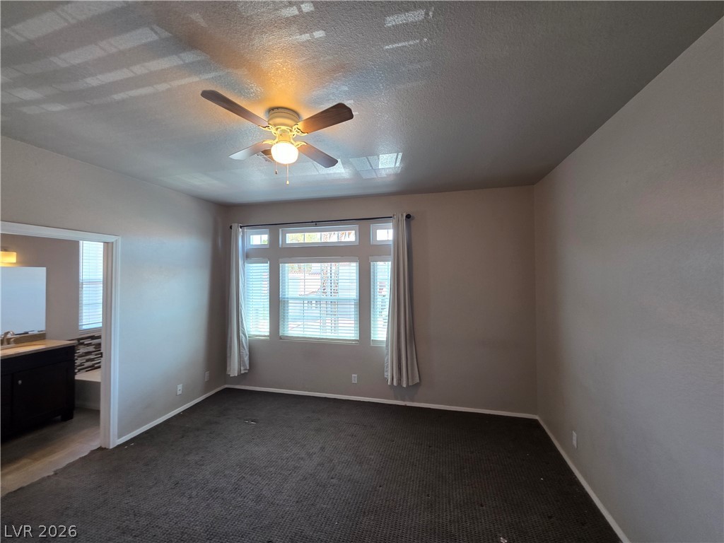 2275 Ramsgate Drive Henderson, NV 89074 - Photo 53 of 84 Well-lit room featuring a ceiling fan and a connecting bathroom vanity area.