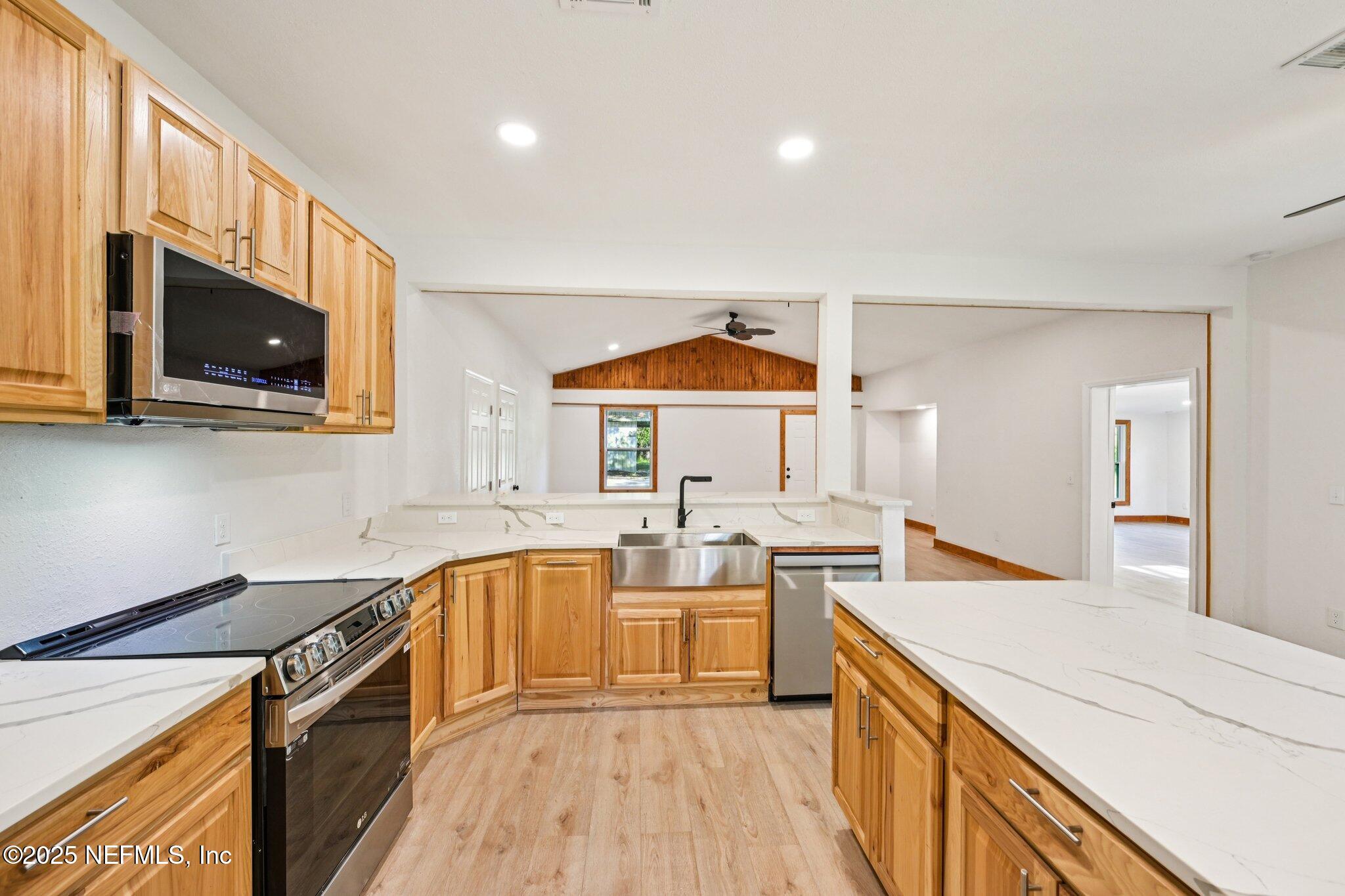 1217 Colley Road Starke, FL 32091 - Photo 14 of 42 a kitchen with a sink a stove top oven and wooden floor