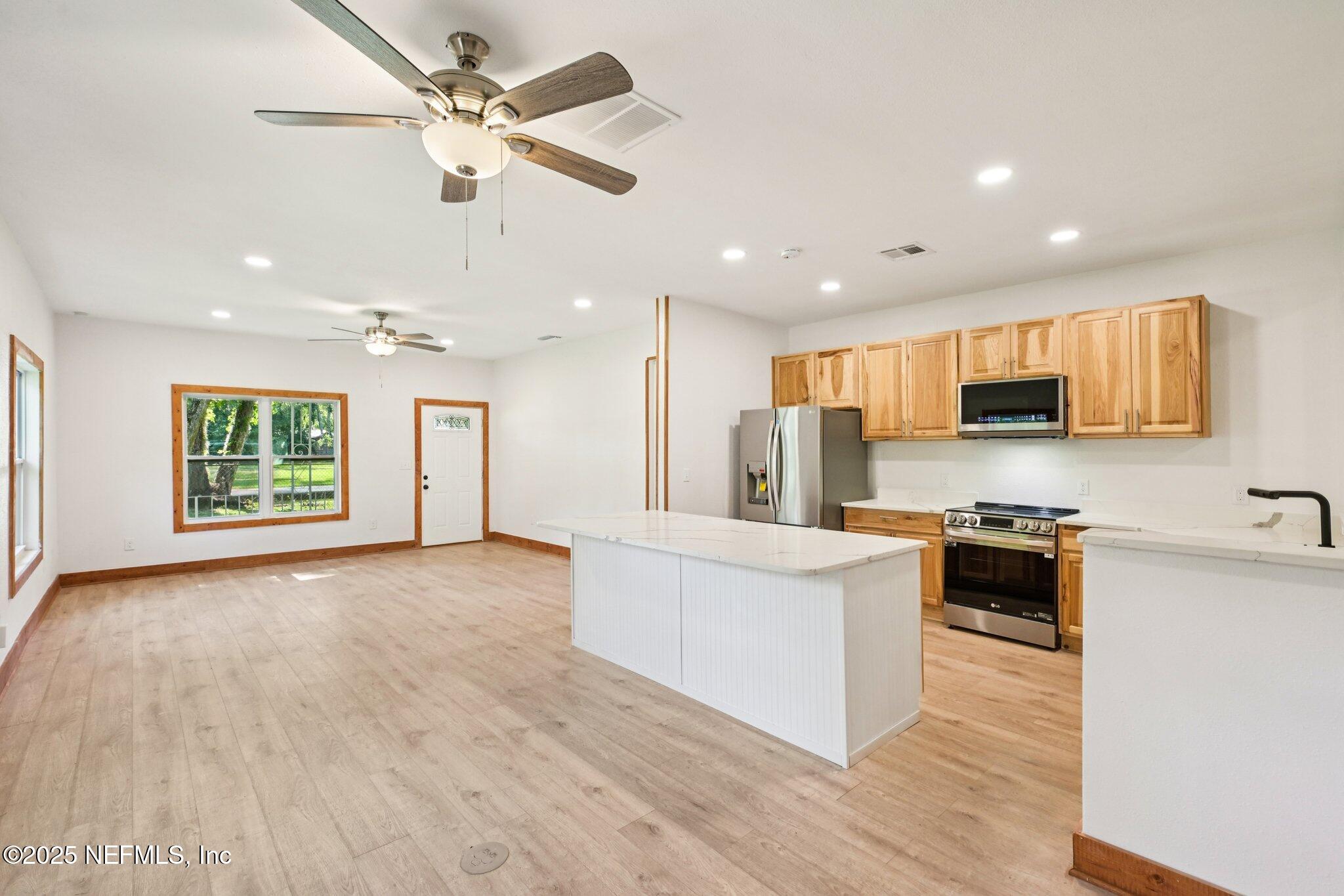 1217 Colley Road Starke, FL 32091 - Photo 15 of 42 a large kitchen with stainless steel appliances granite countertop a stove top oven a refrigerator a sink and a oven