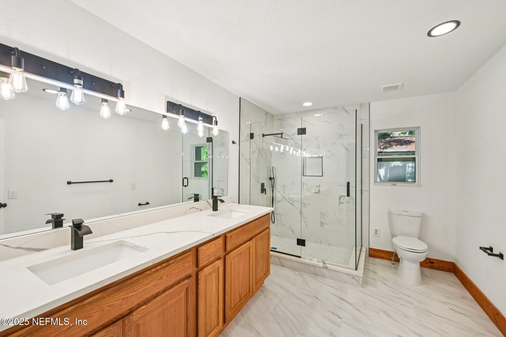 1217 Colley Road Starke, FL 32091 - Photo 24 of 42 a spacious bathroom with a double vanity sink mirror double and shower