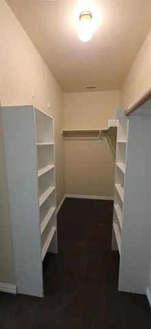 a view of walk in closet with empty racks