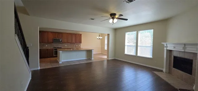 a view of kitchen with granite countertop stainless steel appliances and wooden floor