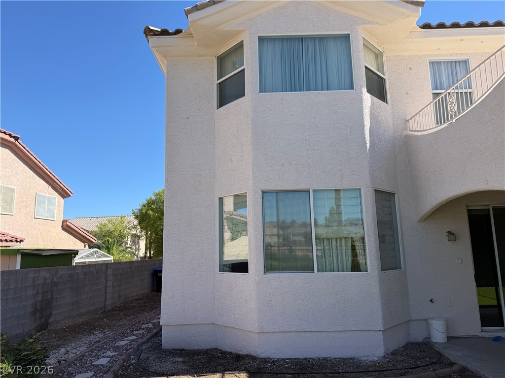 141 Rancho Maria Street Las Vegas, NV 89148 - Photo 26 of 30 A light-colored stucco exterior boasts classic bay windows under a tiled roofline.