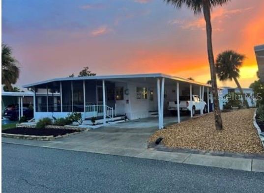 a front view of a house with garden and trees