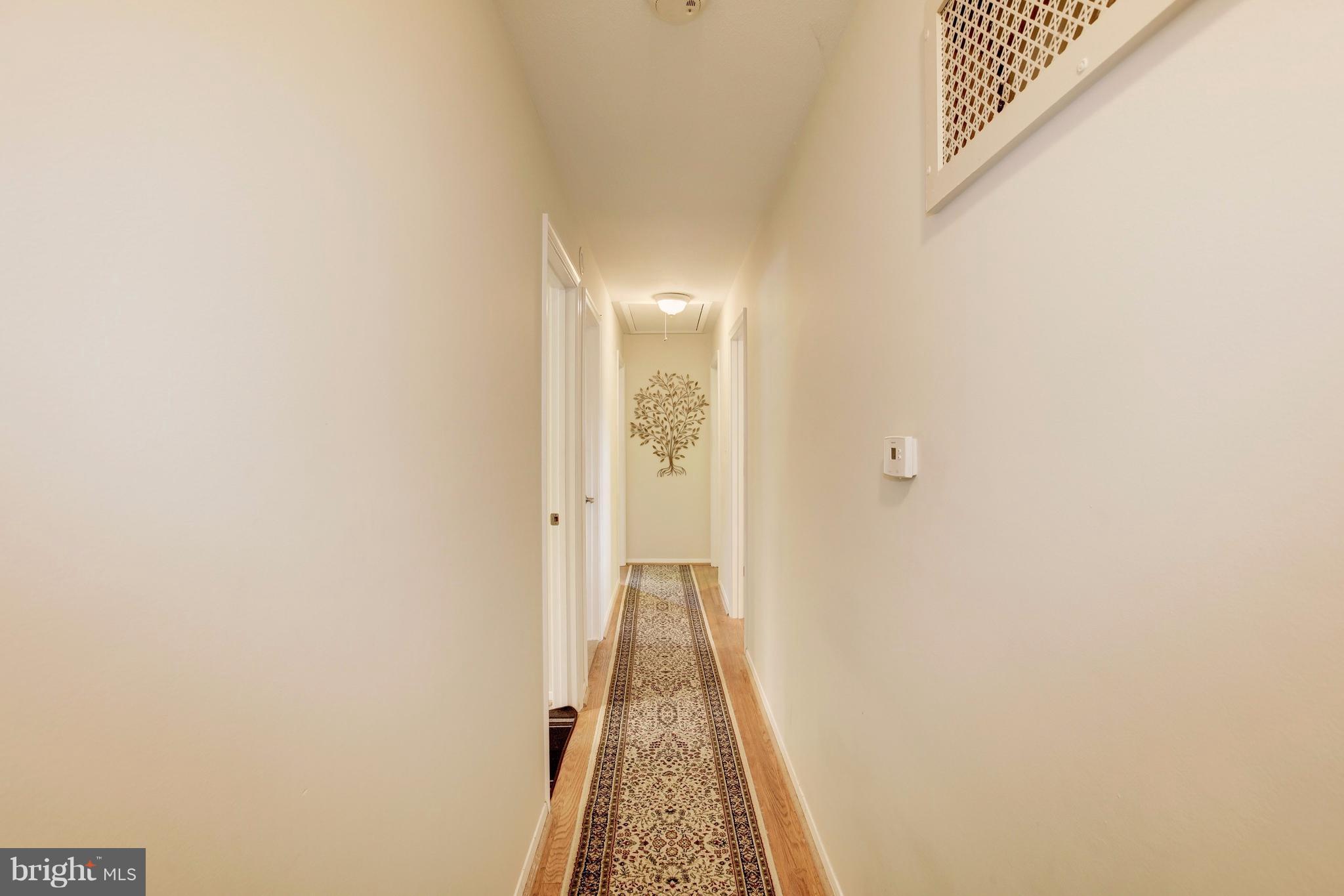 7909 Ellet Road Springfield, VA 22151 - Photo 11 of 30 a view of a hallway with wooden floor and a bathroom