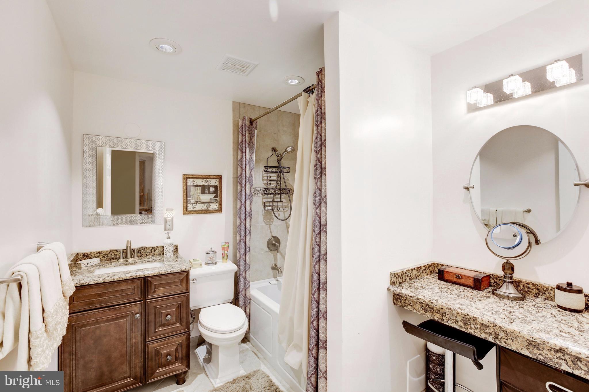 7909 Ellet Road Springfield, VA 22151 - Photo 14 of 30 a bathroom with a granite countertop toilet sink and mirror