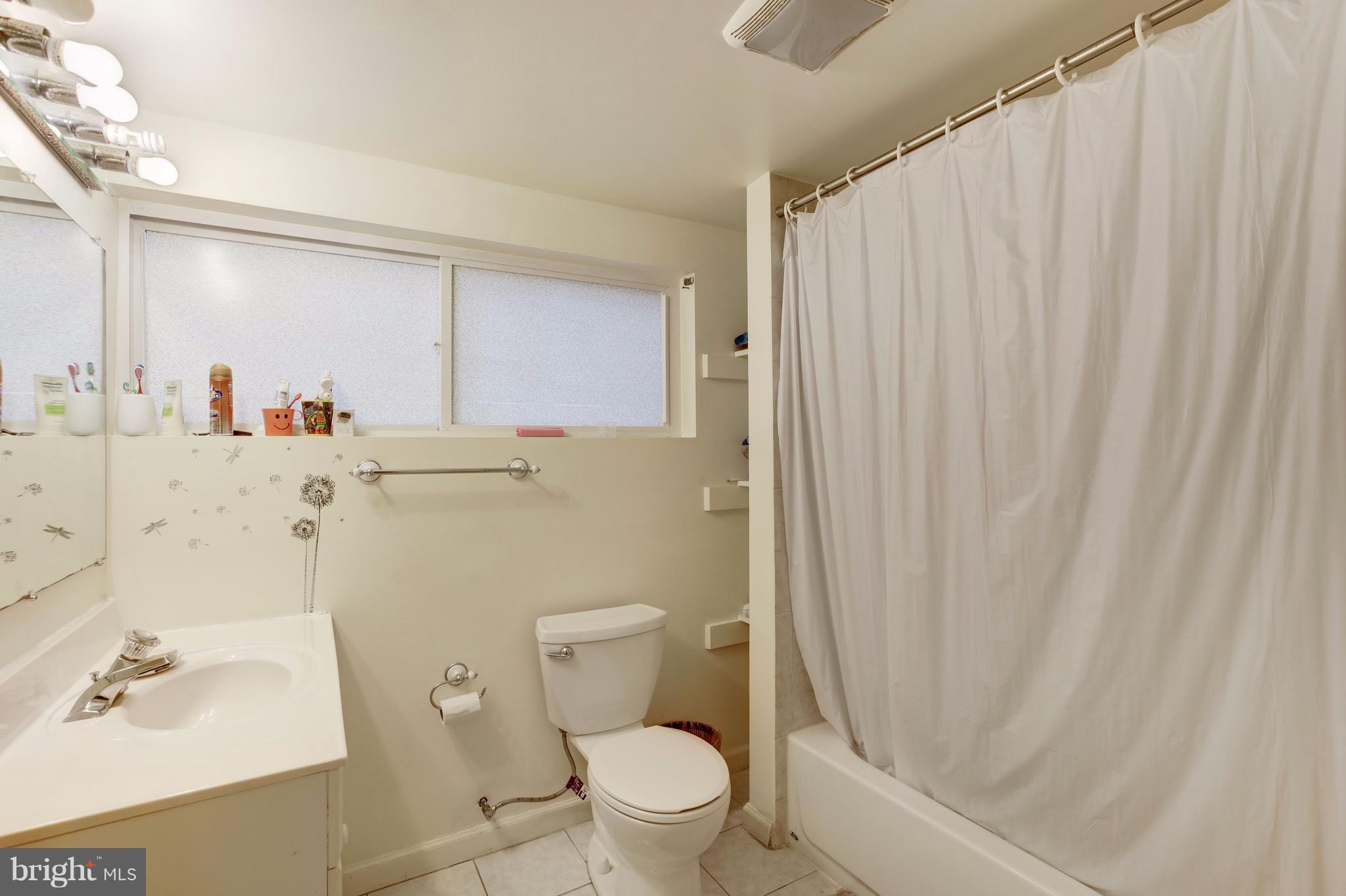 7909 Ellet Road Springfield, VA 22151 - Photo 27 of 30 a bathroom with a sink a toilet and shower curtain