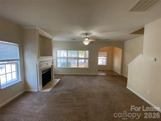 a view of an empty room with a fireplace and a window