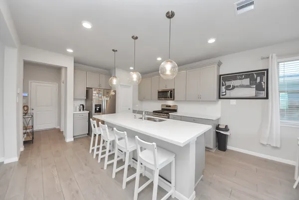 a kitchen with a dining table chairs refrigerator and cabinets