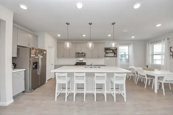 a kitchen with a dining table chairs sink and cabinets