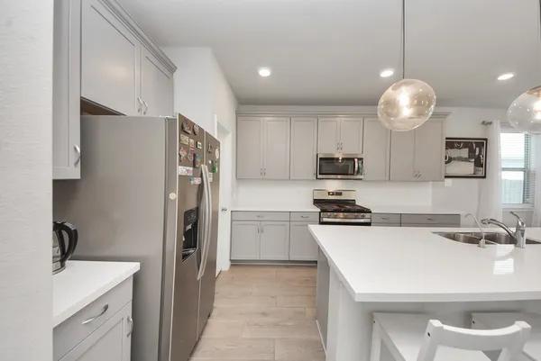a large kitchen with a large counter top appliances and cabinets