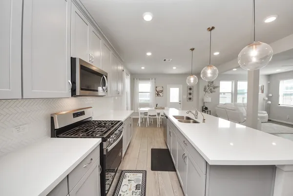 a large kitchen with kitchen island a sink stainless steel appliances and cabinets