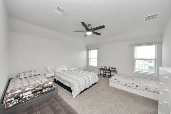 a bedroom with a large bed and a chandelier