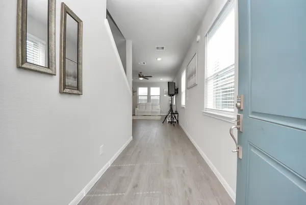 a living room with furniture and kitchen view with wooden floor