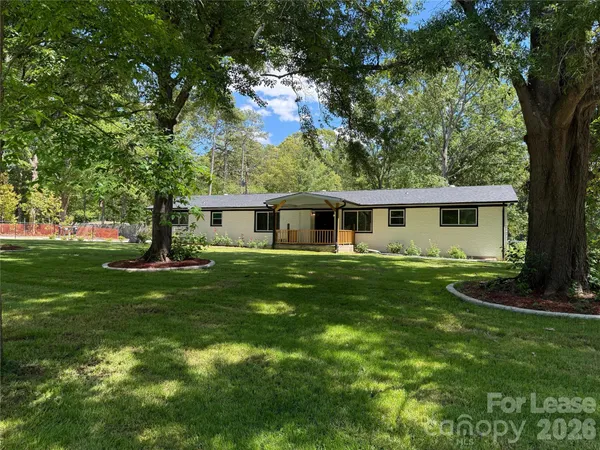 a front view of house with a garden and trees