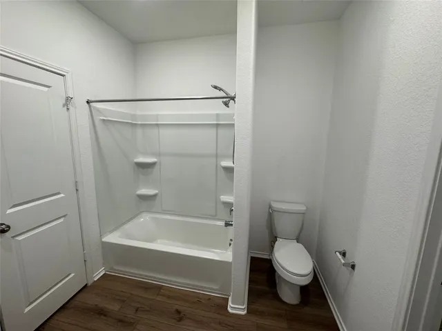 a bathroom with a toilet and a bath tub
