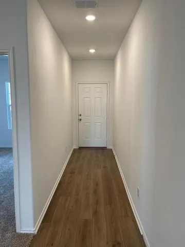a view of a hallway with wooden floor