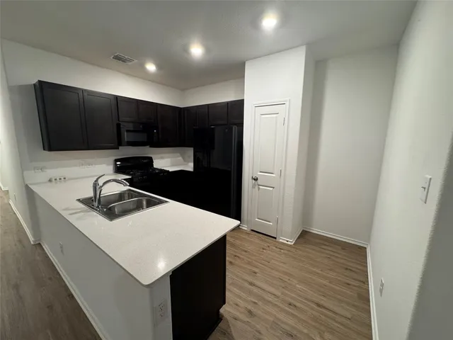 a kitchen with a sink a stove and cabinets