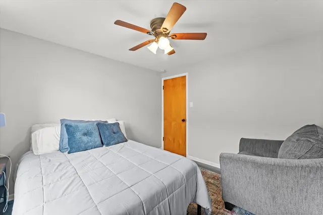a bedroom with a bed and a ceiling fan