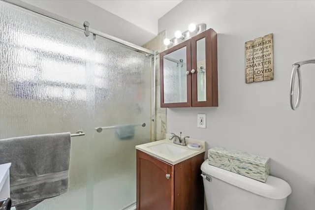 a bathroom with a sink mirror vanity and toilet