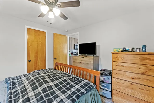 a bedroom with a bed and a flat tv screen on dresser