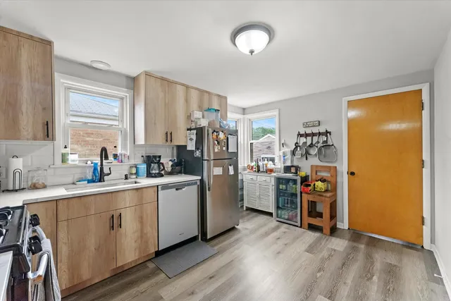 a kitchen with stainless steel appliances a sink cabinets and wooden floor