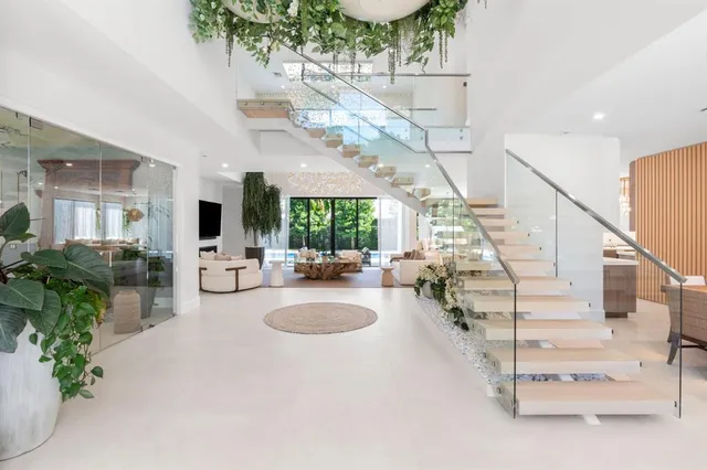 a kitchen with stainless steel appliances a refrigerator a sink dishwasher a oven with a dining table and chairs