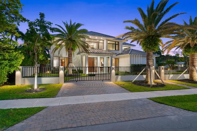 a view of a house with a yard and large trees