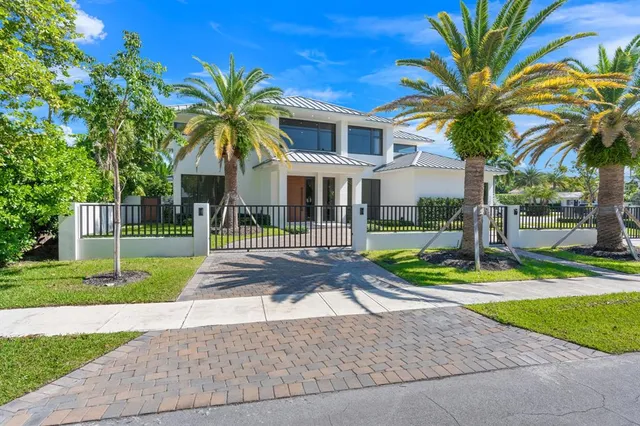 a front view of a house with a yard and potted plants