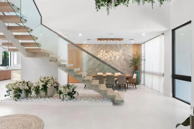 a backyard of a house with table and chairs plants and large trees