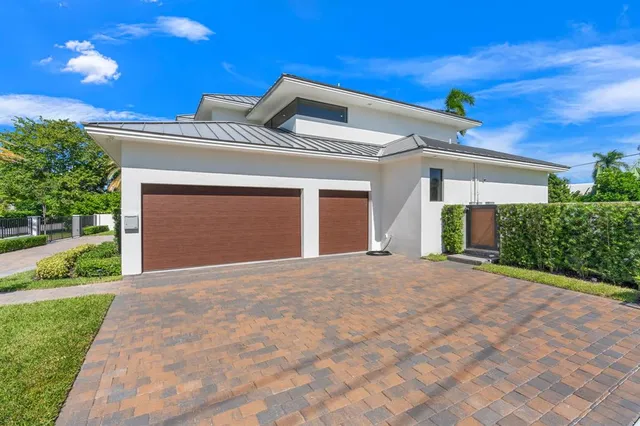 a view of a house with a yard and potted plants
