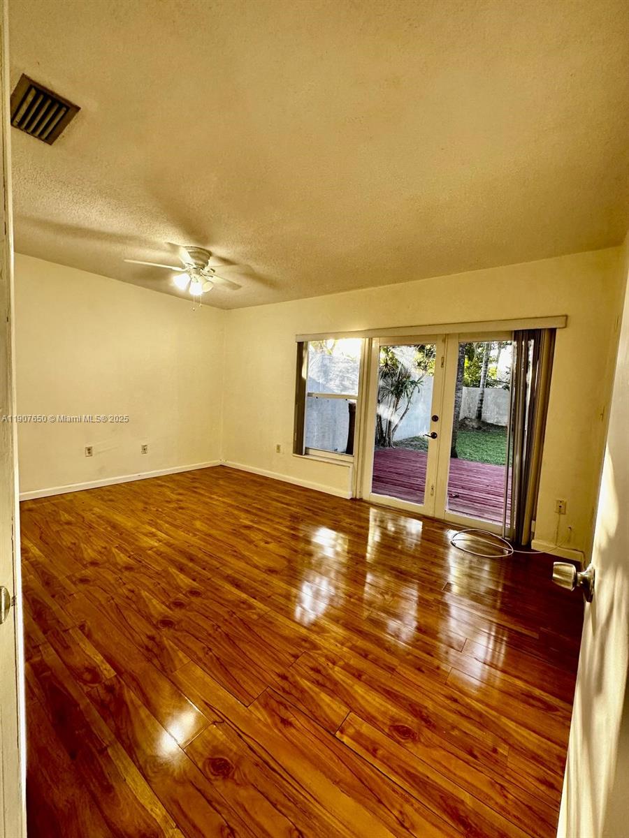 8420 Southwest 102nd Avenue, Unit 8420 Miami, FL 33173 - Photo 7 of 12 a view of an empty room with window and wooden floor