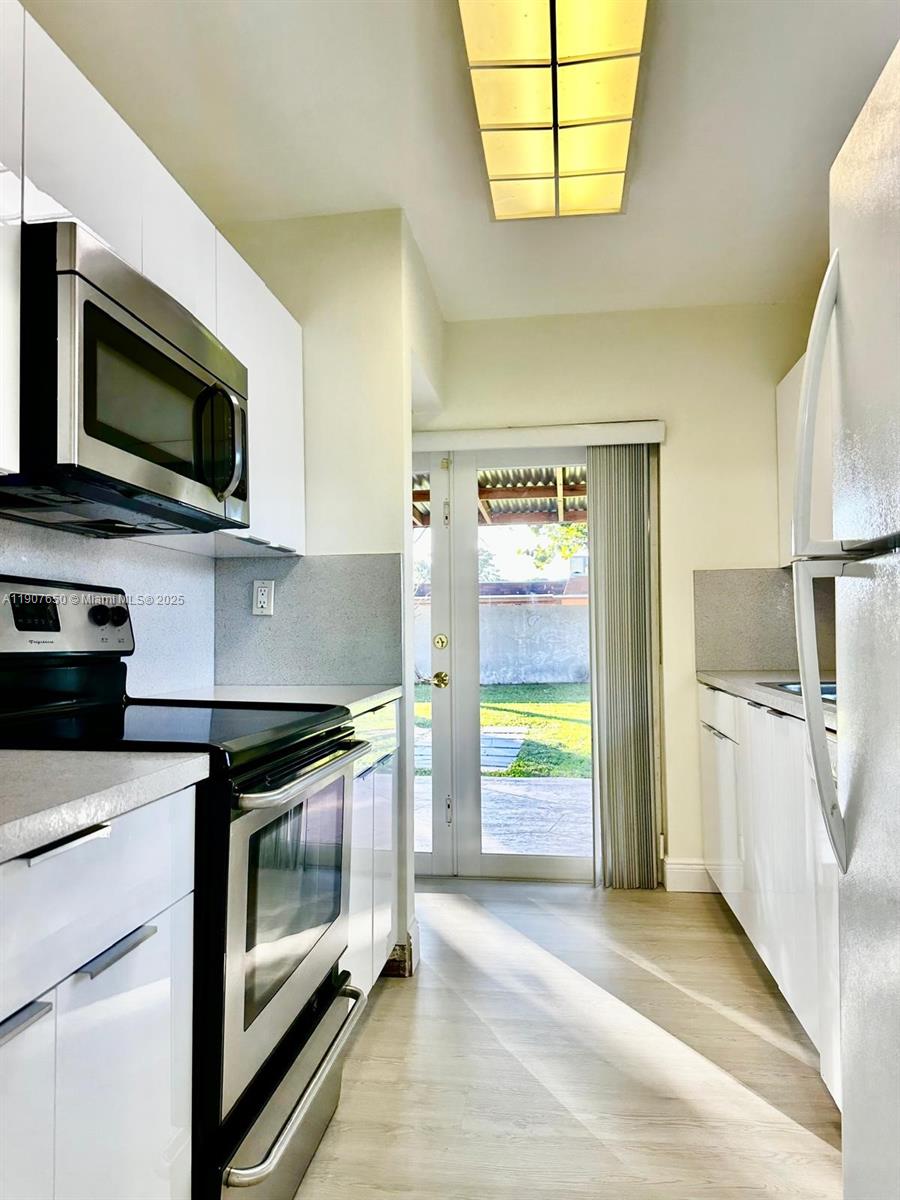 8420 Southwest 102nd Avenue, Unit 8420 Miami, FL 33173 - Photo 8 of 12 a kitchen with stainless steel appliances a stove microwave and refrigerator