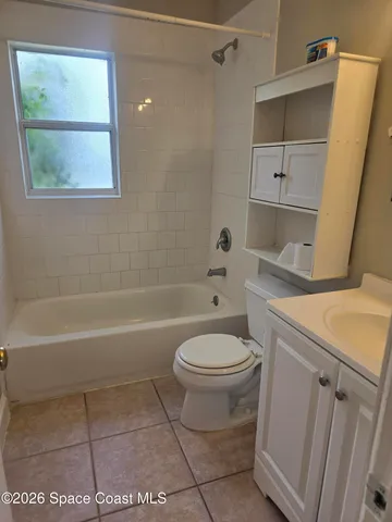 a view of an empty room with closet and a window
